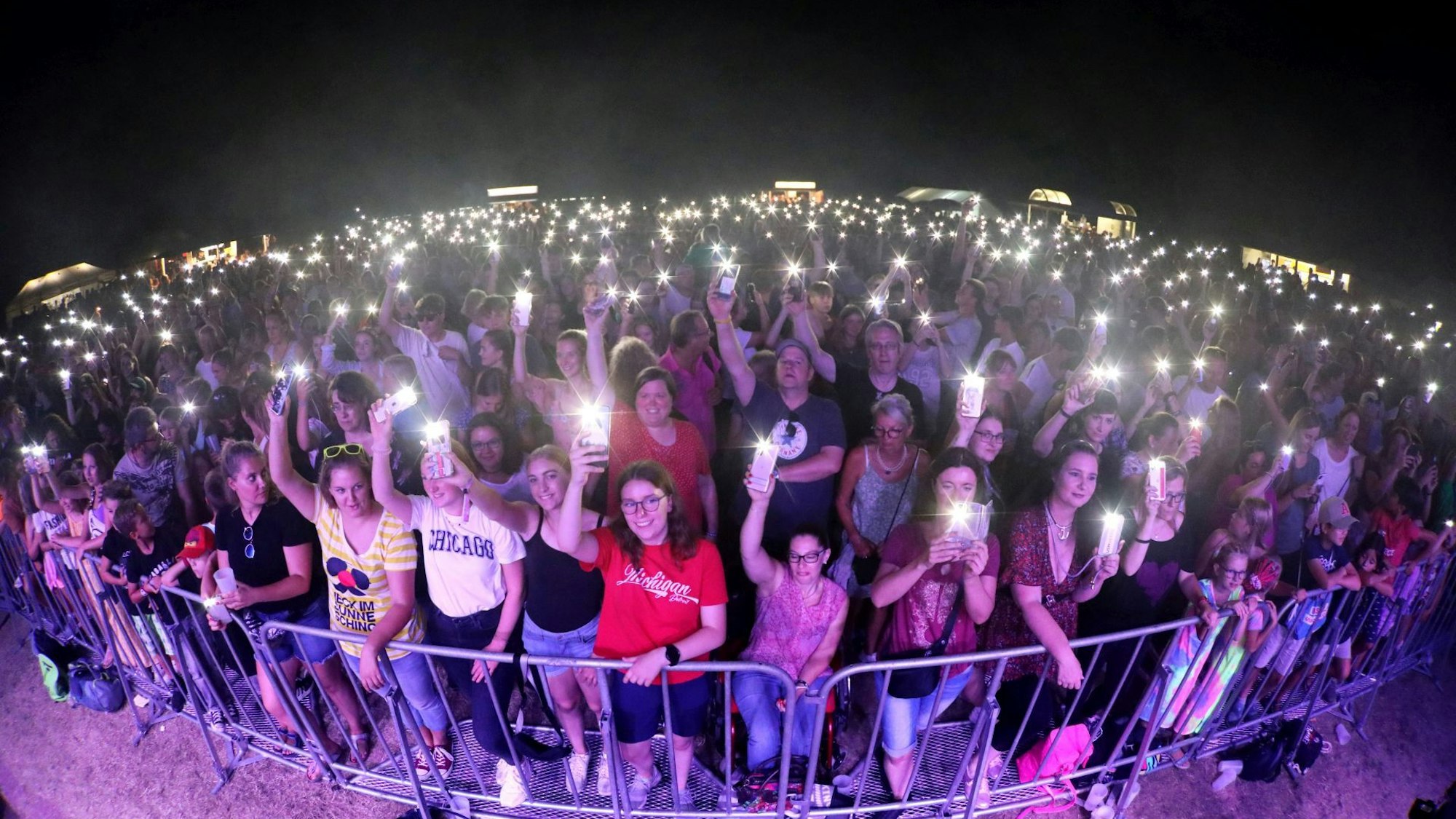 Hunderte Konzertbesuchende stehen hinter einer Absperrung.