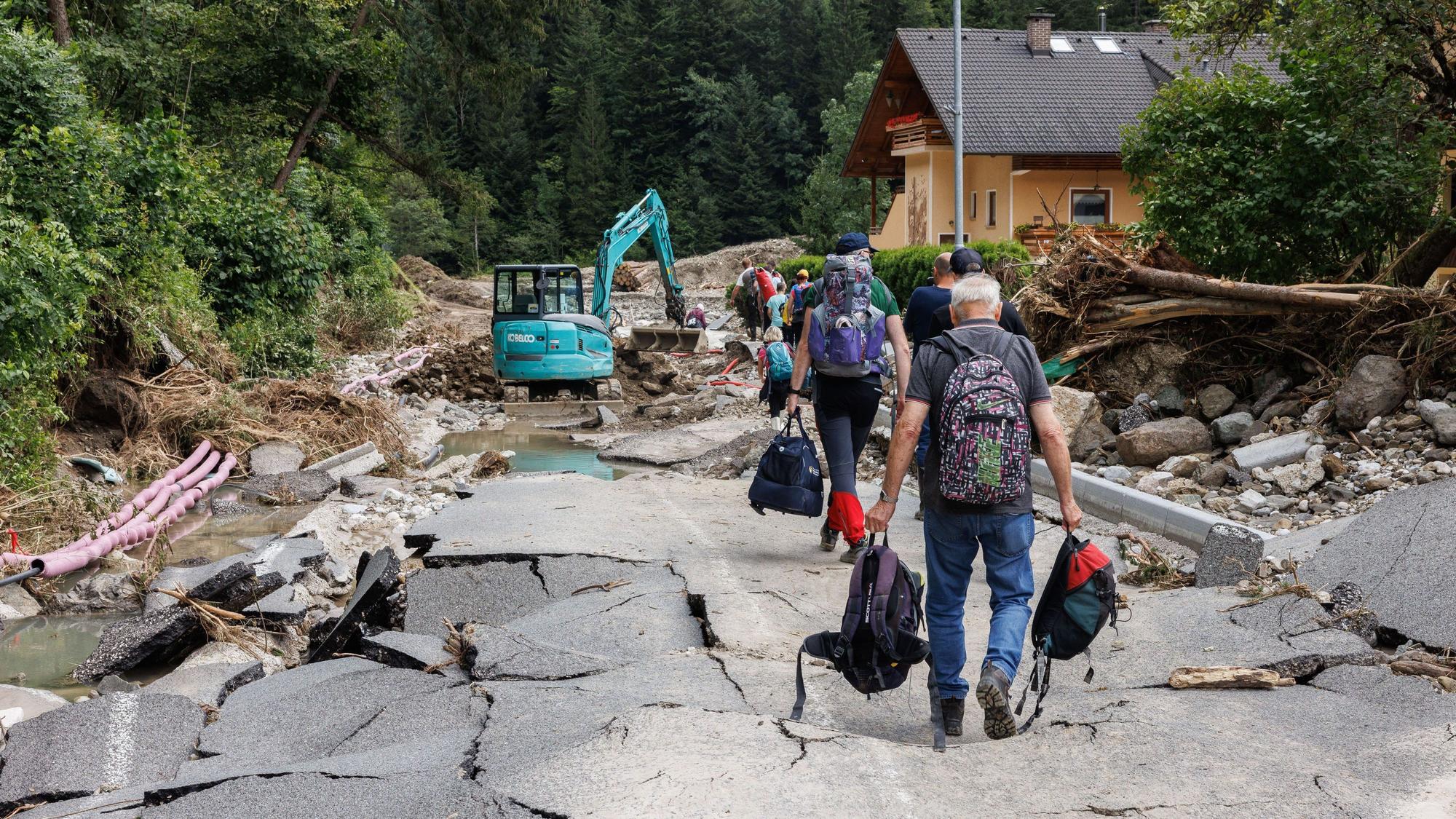 Slowenien, Raduha: Menschen verlassen mit ihrem Hab und Gut ein überschwemmtes Dorf.