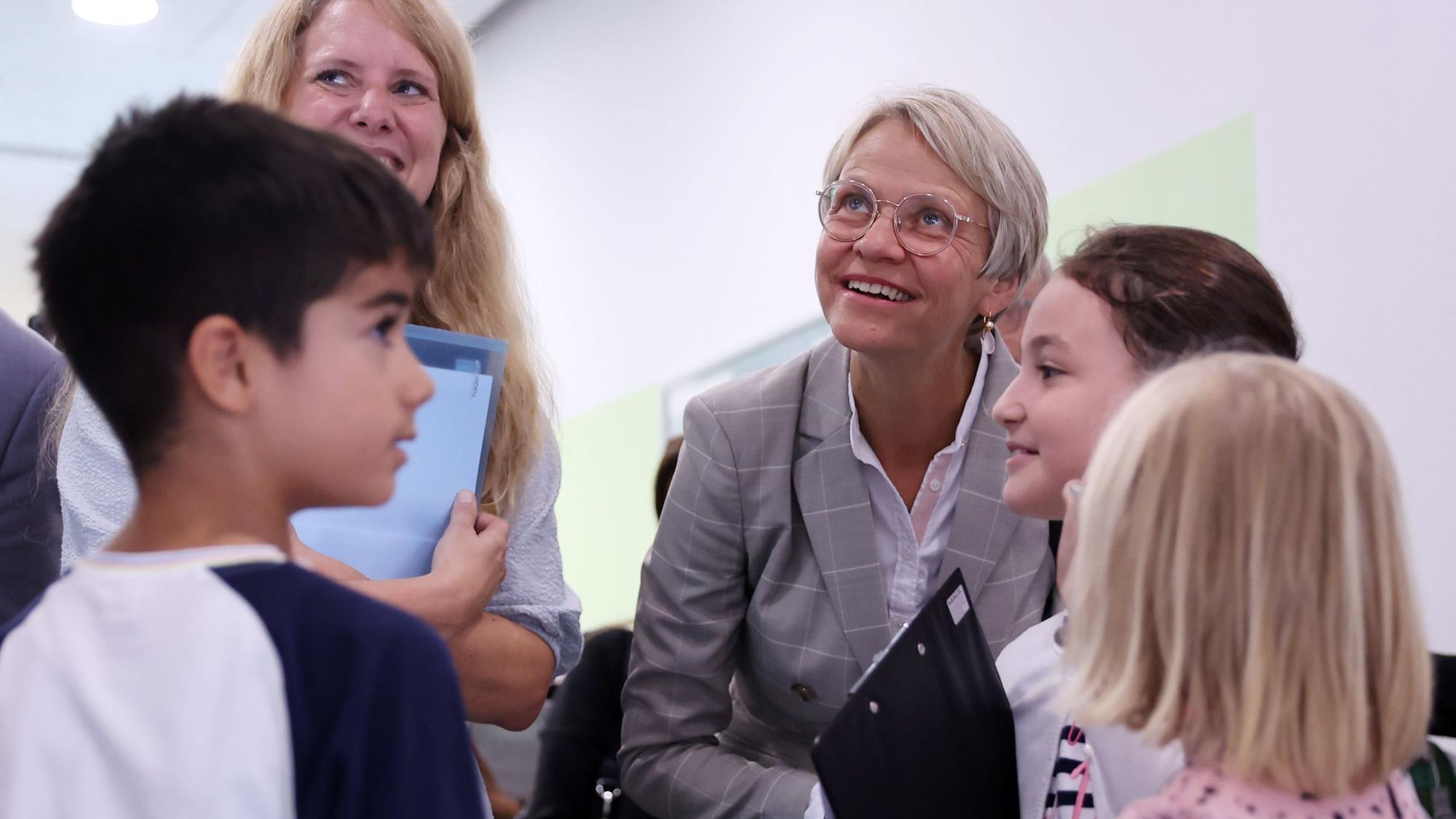 Besuch von NRW-Schulministerin Dorothee Feller an der Grundschule Alzeyer Straße in Köln-Bilderstöckchen. Die 3 SchülerInnen Malu, Sude und Mert begleiten sie durch die Schule und stellen ihr Aufgaben.
Schulleiterin Rebekka Sachs im blauen Kleid
