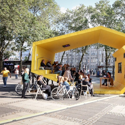 In einem gelben Pavillon liest die Autorin Lisa Ray vor Publikum.