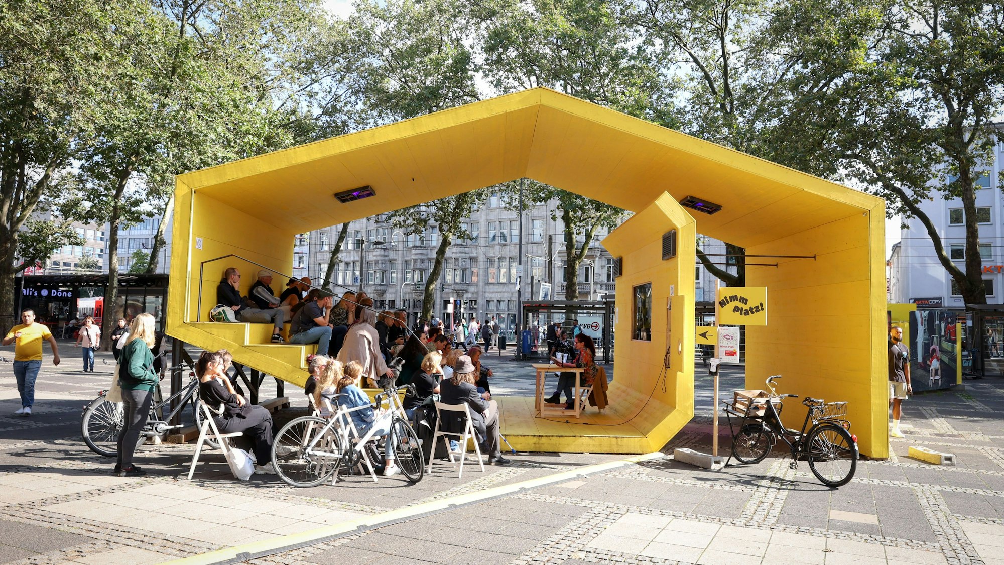 In einem gelben Pavillon liest die Autorin Lisa Ray vor Publikum.