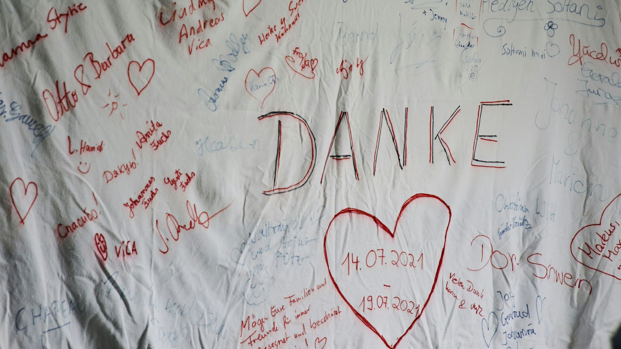 Das Bild zeigt das Tuch im Feuerwehrgerätehaus. Viele Menschen haben darauf unterschrieben.