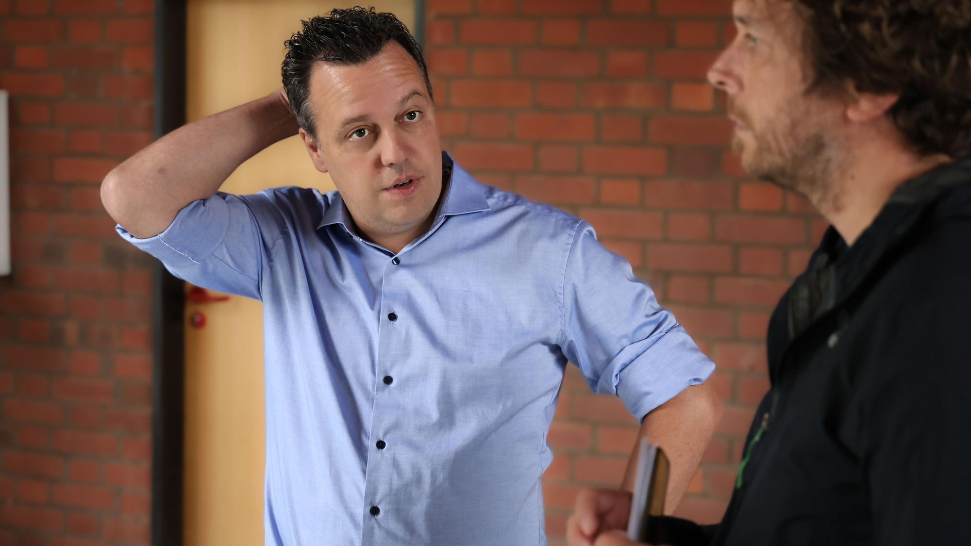 Das Bild zeigt Sacha Reichelt, wie er sich am Kopf kratzt. Redakteur Tom Steinicke steht rechts neben ihm.