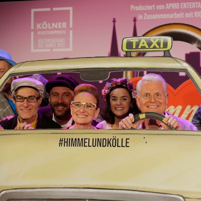 Zahlreiche Darsteller in einer Taxi-Kulisse