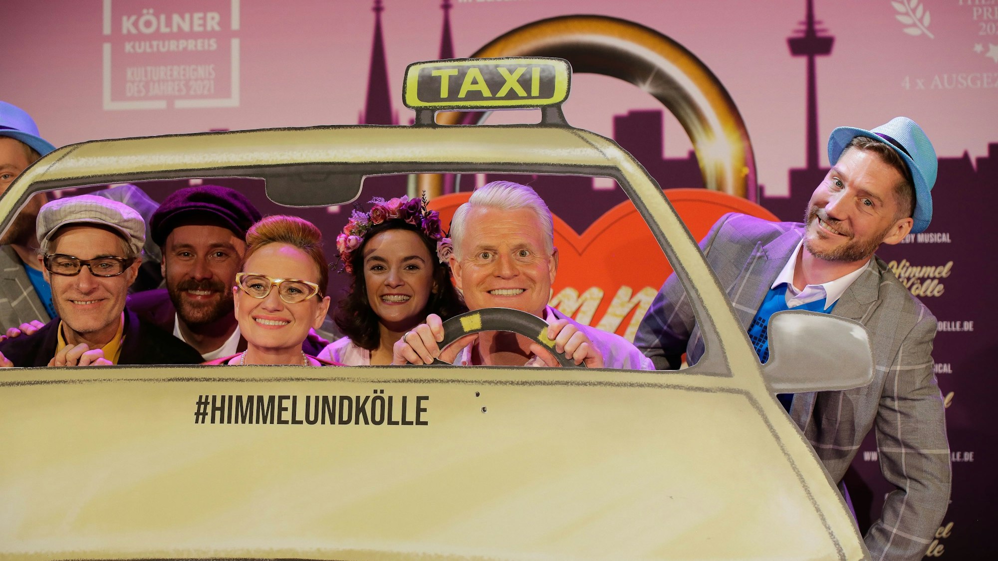 Zahlreiche Darsteller in einer Taxi-Kulisse