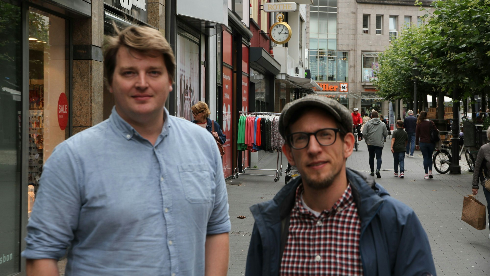 Zwei Männer stehen in der Fußgängerzone von Siegburg.