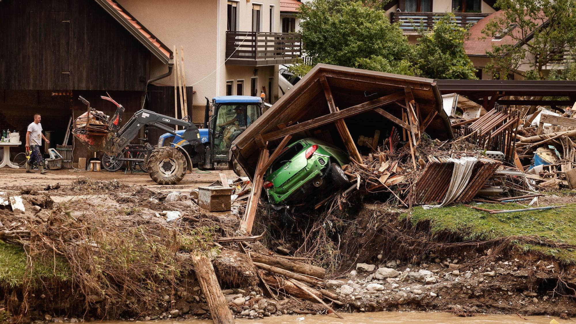 In Slowenien hat das Wasser große Zerstörungen verursacht. Hier sind ein zerstörtes Haus, ein Auto und angeschwemmter Unrat zu sehen. Die Bilder gleichen denen nach der Flutkatastrophe 2021 im Kreis Euskirchen.