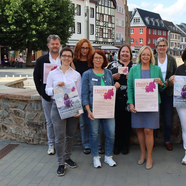 Die Organisatoren der Frauen-Stärken-Wochen und Schirmherrin Sabine Preiser-Marian stehen auf einer Brücke in Bad Münstereifel und präsentieren das Programm.