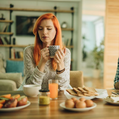 Mann und Frau beim Frühstück. Mann ist abgelenkt vom Smartphone.