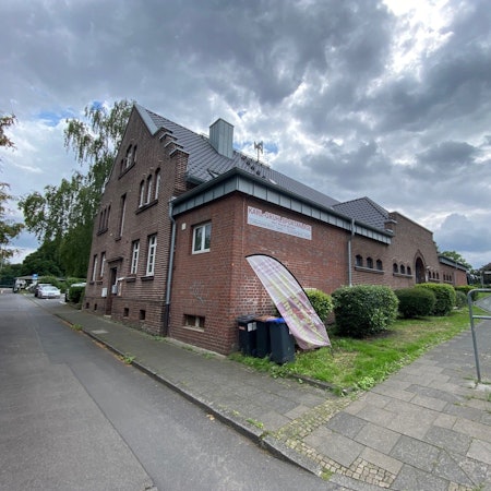 Die Turnhalle in Brühl-Heide ist ein alter Bau aus weinrotem Backstein.