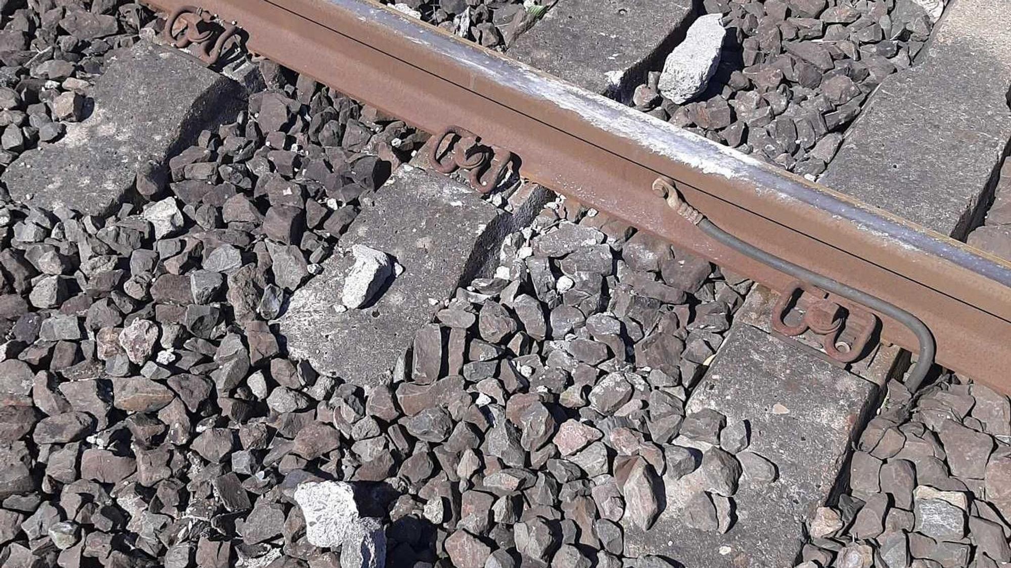 Rechts und links einer Schiene liegen die Trümmer eines Steins, der von einer S-Bahn überrollt wurde.