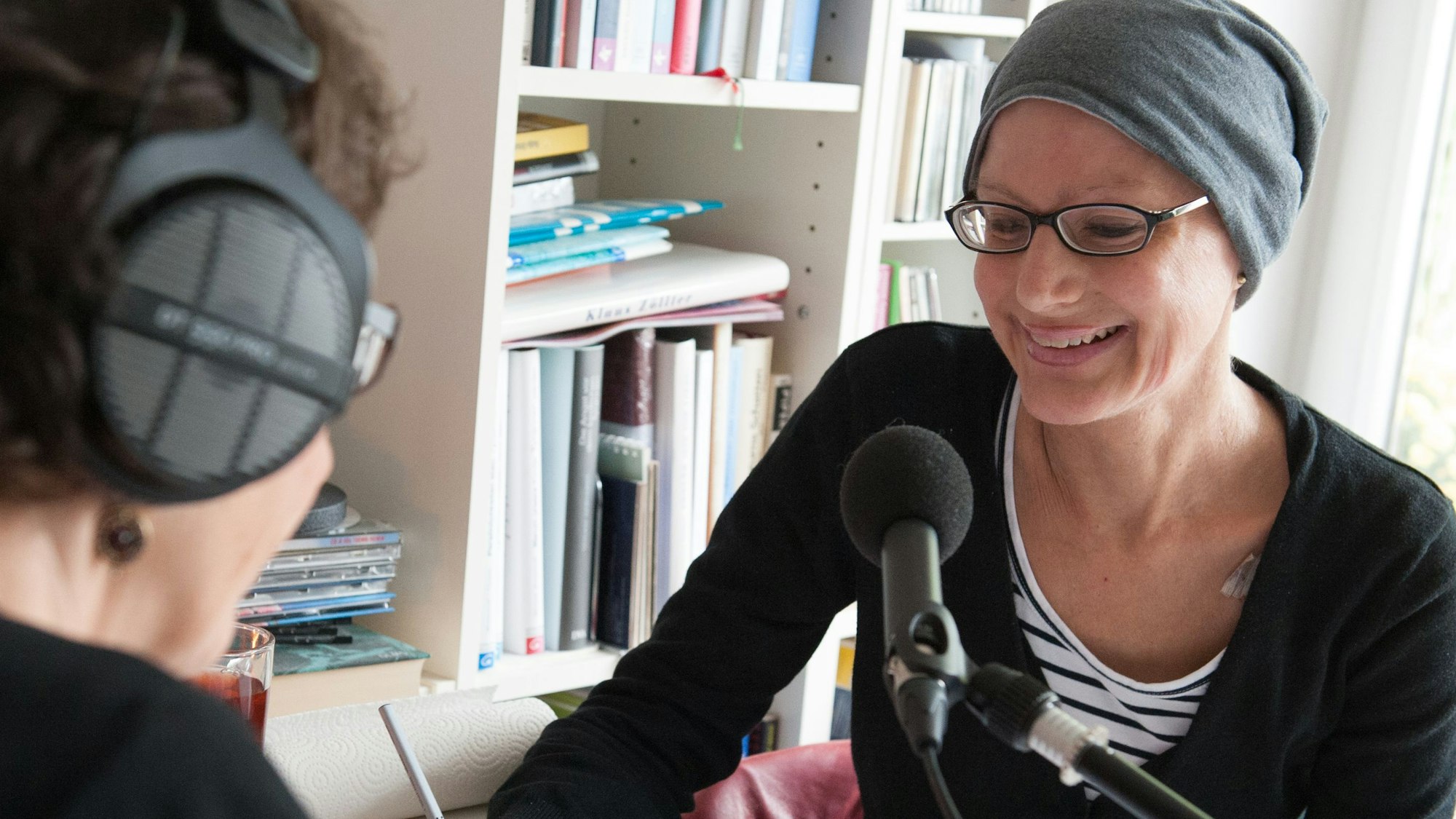 Eine schwerkranke Mutter mit Beanie sitzt im Tonstudio der Kölner „Familienhörbuch gGmbH“ vor einem Toningenieur, um Abschiedstöne für ihre Tochter aufzunehmen.