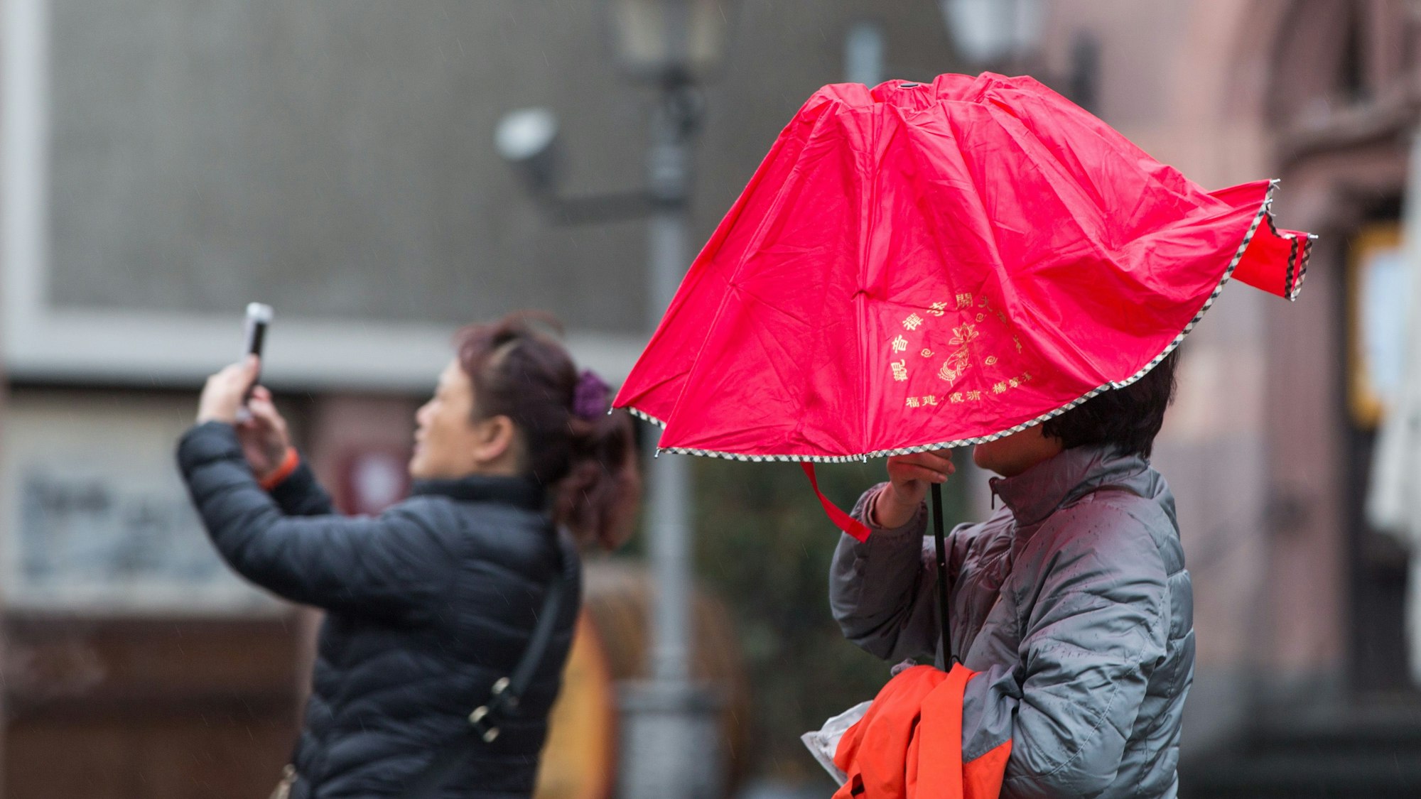 Eine Touristin steht mit ihrer chinesischen Reisegruppe auf dem Frankfurter Römerberg (Symbolbild).