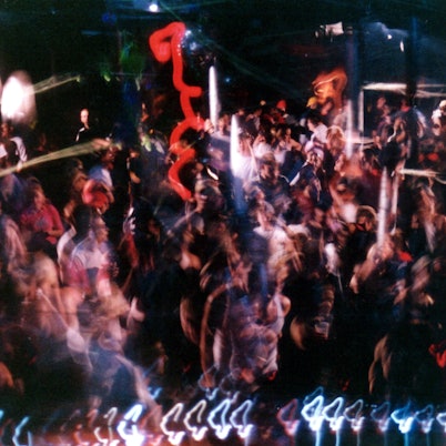 Ansicht eines gefüllten Clubs. Die Menschen und Lichter sind verschwommen.