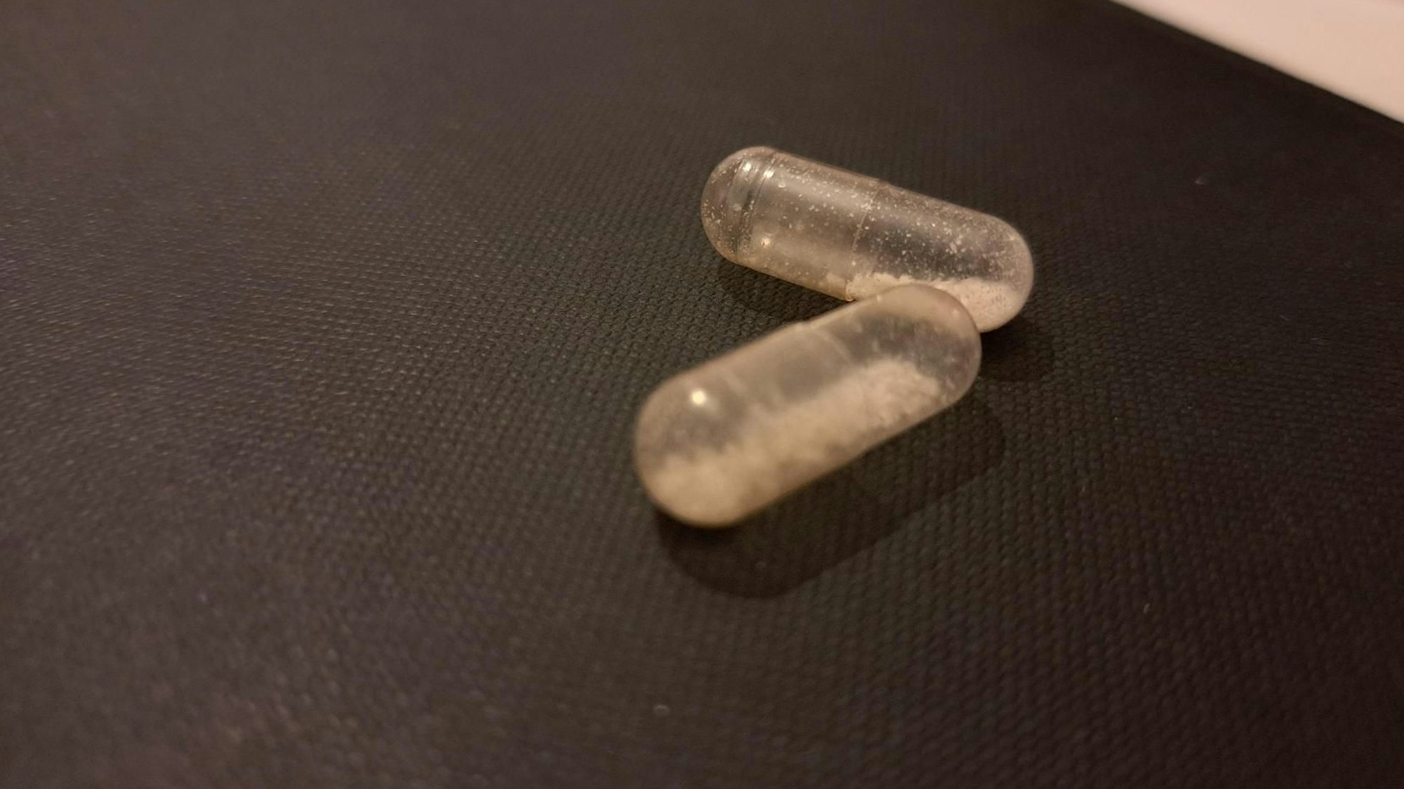 MDMA liegt auf einem Tisch, es ist in Kapseln abgefüllt.