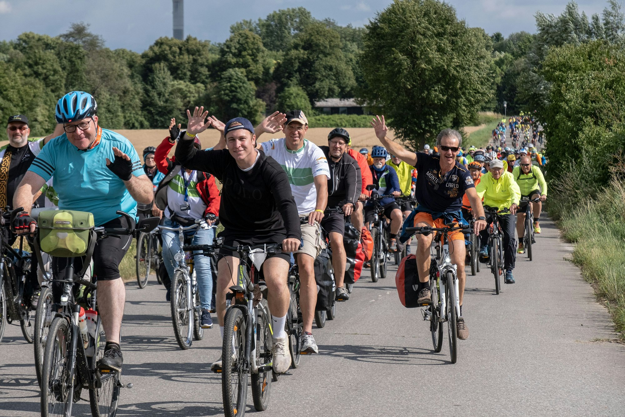 NRW-Radtour 2022, viele Radfahrer als Kolonne auf der Straße.