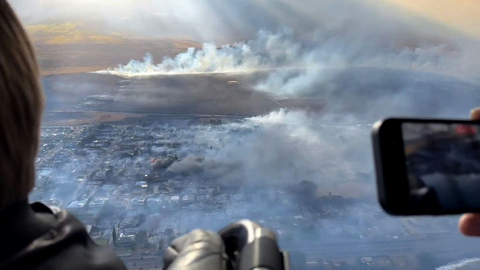 Rauch steigt aus zerstörten Gebäuden auf, während Waldbrände auf Maui, Hawaii, lodern.