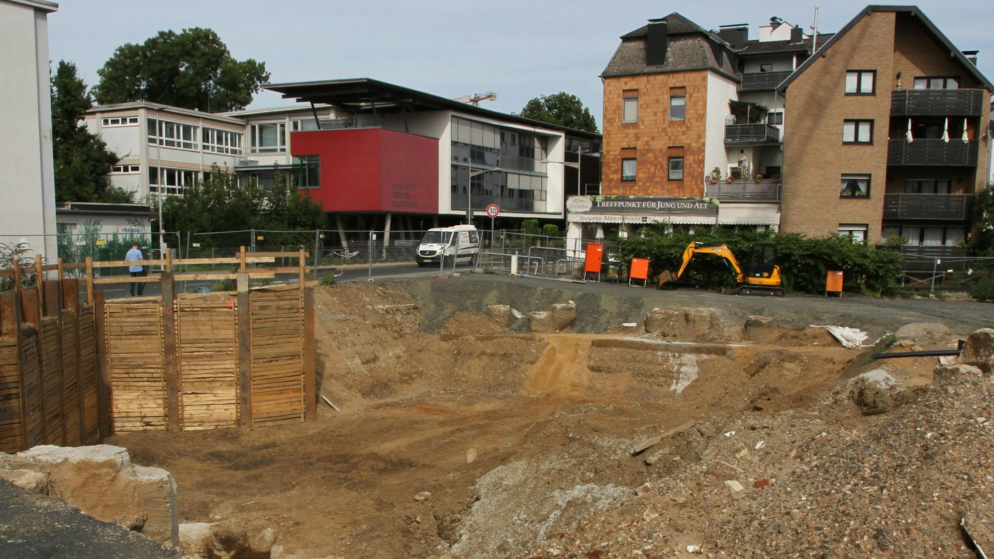 Eine Baugrube mit einer Häuserzeile im Hintergrund