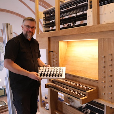 Orgelbauer Martin Hiltmann am Spieltisch der Entdeckerorgel.