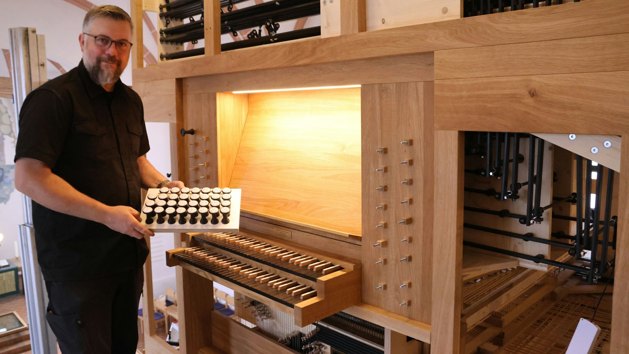 Orgelbauer Martin Hiltmann am Spieltisch der Entdeckerorgel.