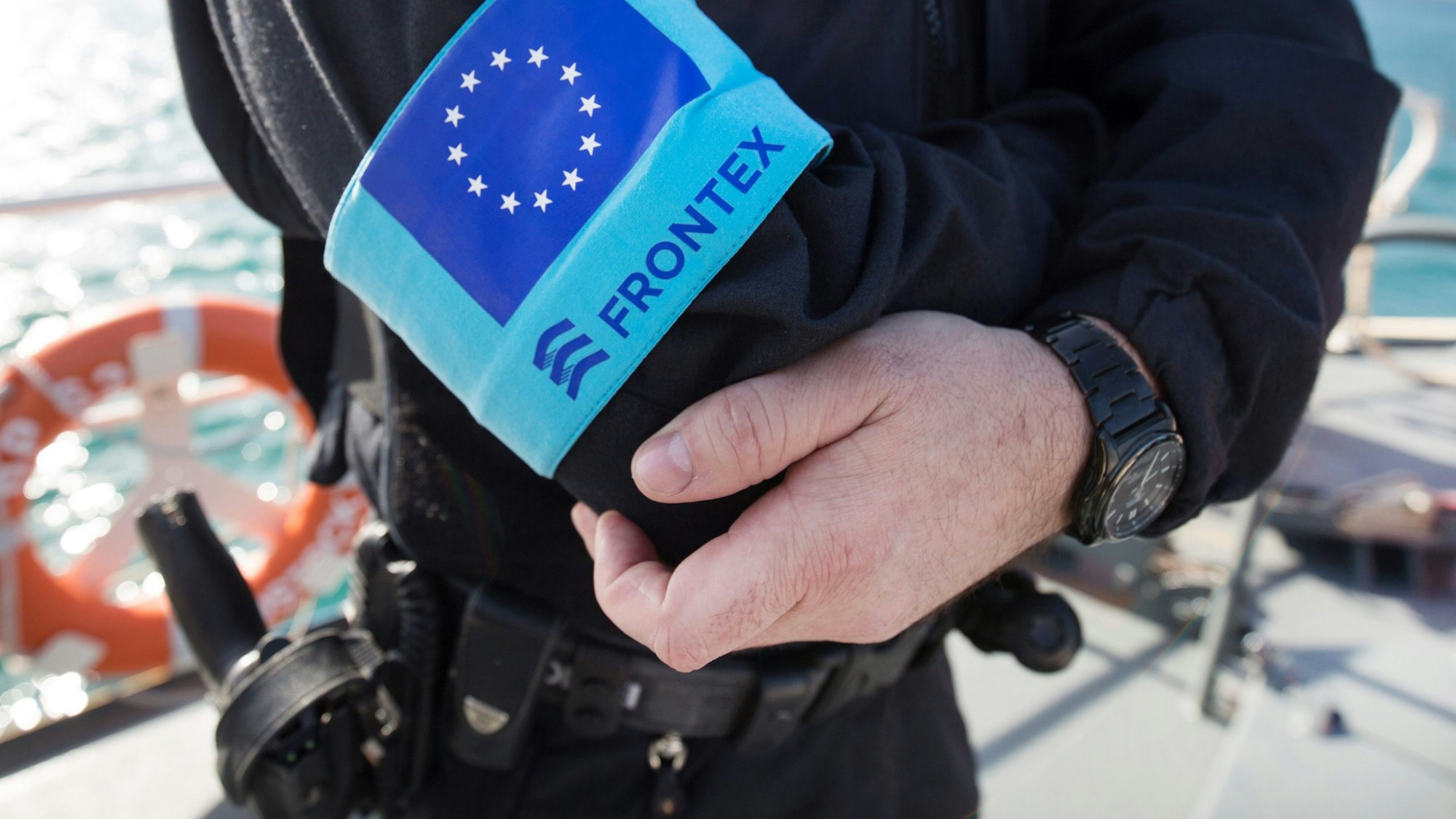 Ein Polizist der EU-Grenzschutzagentur Frontex steht im Hafen der Insel Samos auf dem Vordeck eines Streifenboots vor einer Erkundungsfahrt.
