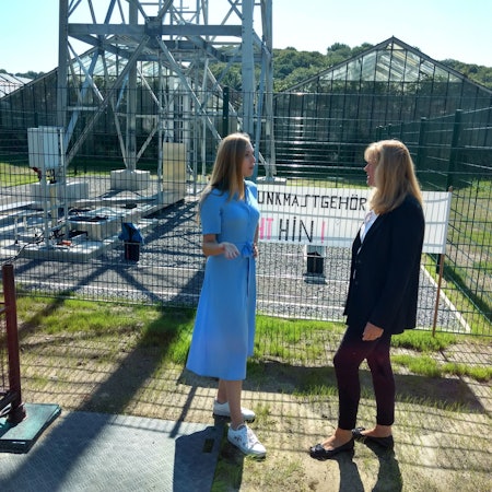 Annabel und Gabi von Clanner stehen vor einem Zaun. Hinter dem soll ein Mobilfunkmast aufgebaut werden.