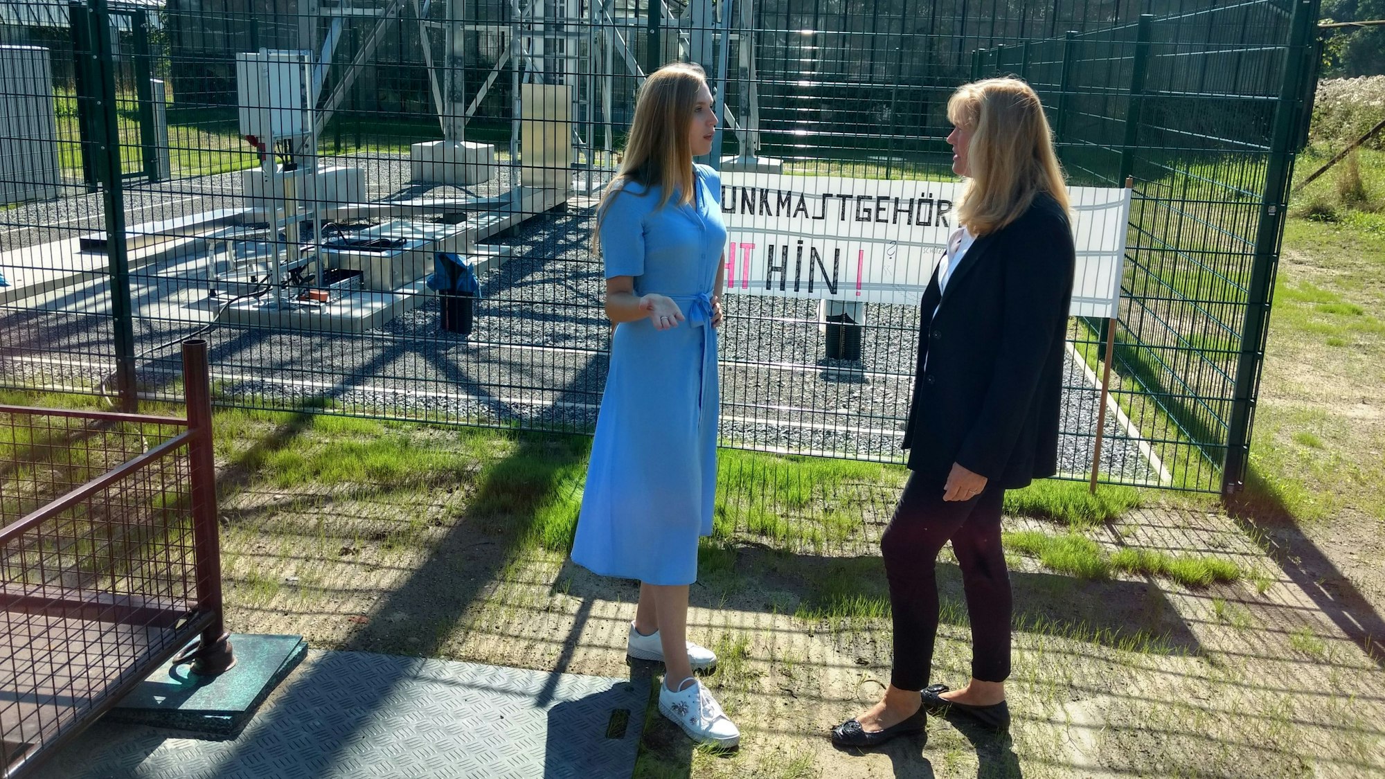 Annabel und Gabi von Clanner stehen vor einem Zaun. Hinter dem soll ein Mobilfunkmast aufgebaut werden.