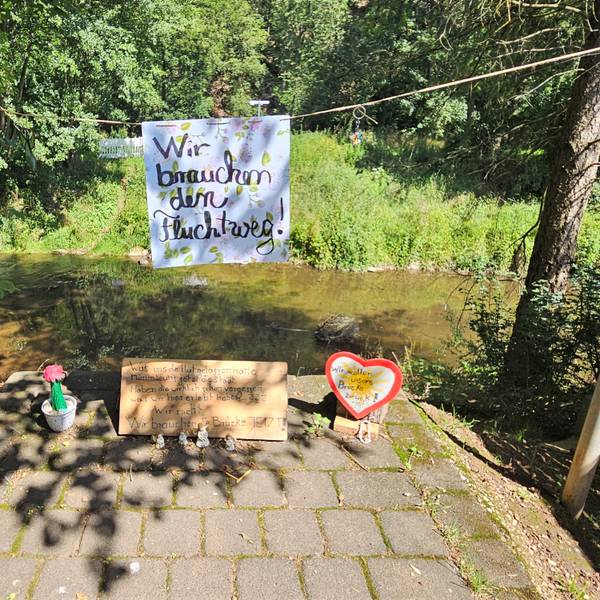Auf dem Aufgang zur abgerissenen Brücke in Mauel hängt an einer Kordel ein Schild der Anwohner mit der Aufschrift „Wir brauchen den Fluchtweg“.