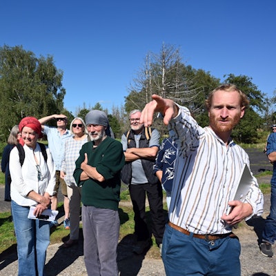 Johannes Thema von der „Wind in der Nutscheid“ (rechts) zeigt Interessierten und Waldbröler Politikerinnen und Politik am Hohen Wäldchen, wo auf dem Nutscheid-Höhenzug die Windräder platziert werden könnten.