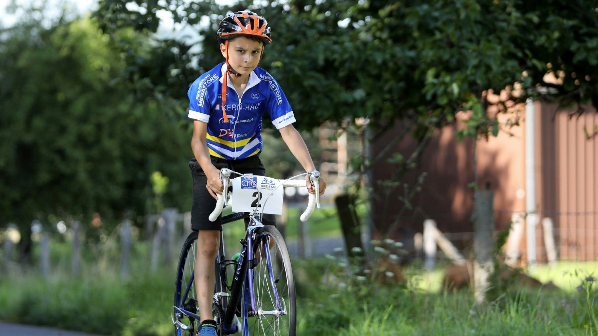 Ein Kind ist auf einem Rennrad unterwegs.