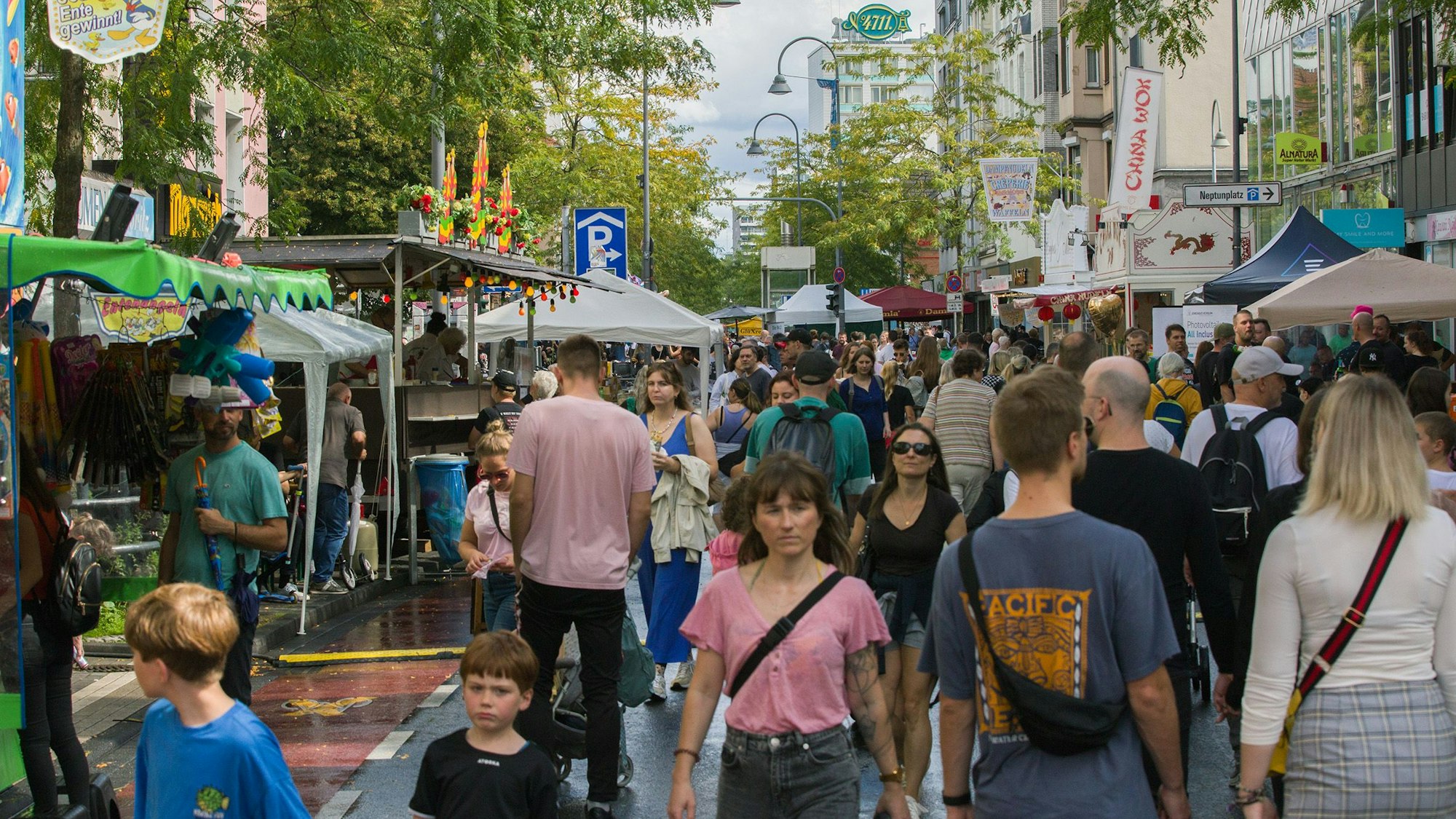 Viele Menschen laufen auf der Venloer Straße, auf der links und rechts Stände aufgebaut sind.