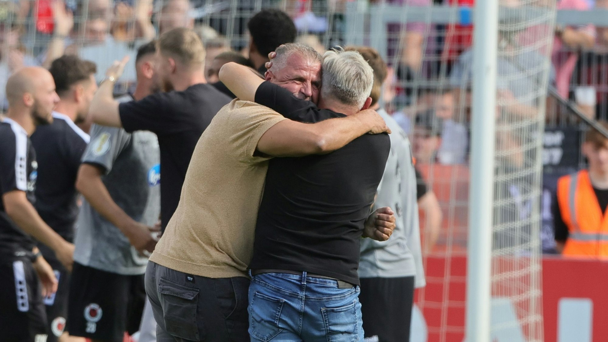 Viktoria-Sportvorstand Franz Wunderlich und Trainer Olaf Janßen (r.) fallen sich nach dem Schlusspfiff in die Arme.