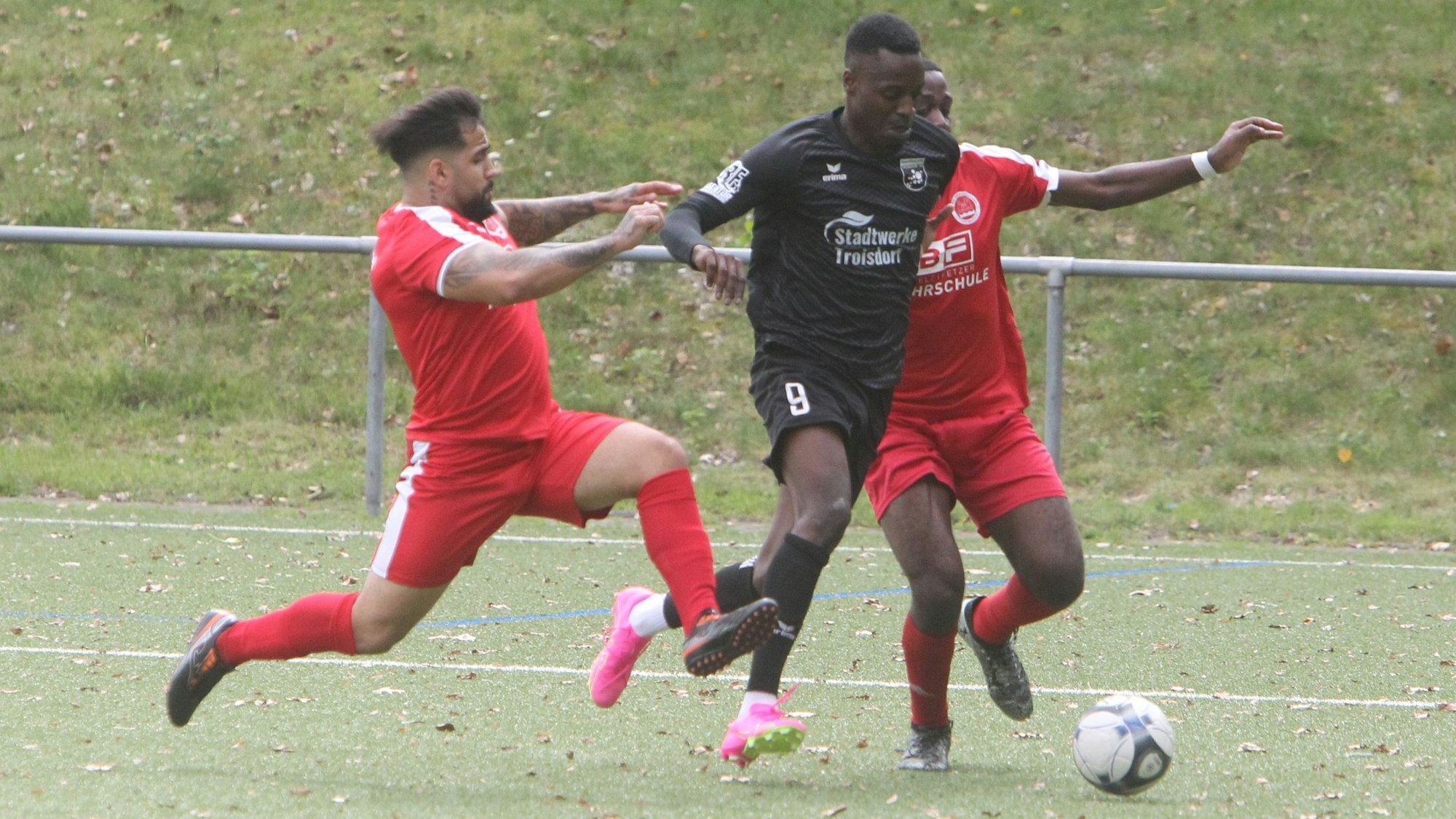 Der Troisdorfer Mimbo-Nsa Mimbala wird von Dorian Madani (links) und Christian Tchemi (rechts) in die Zange genommen.