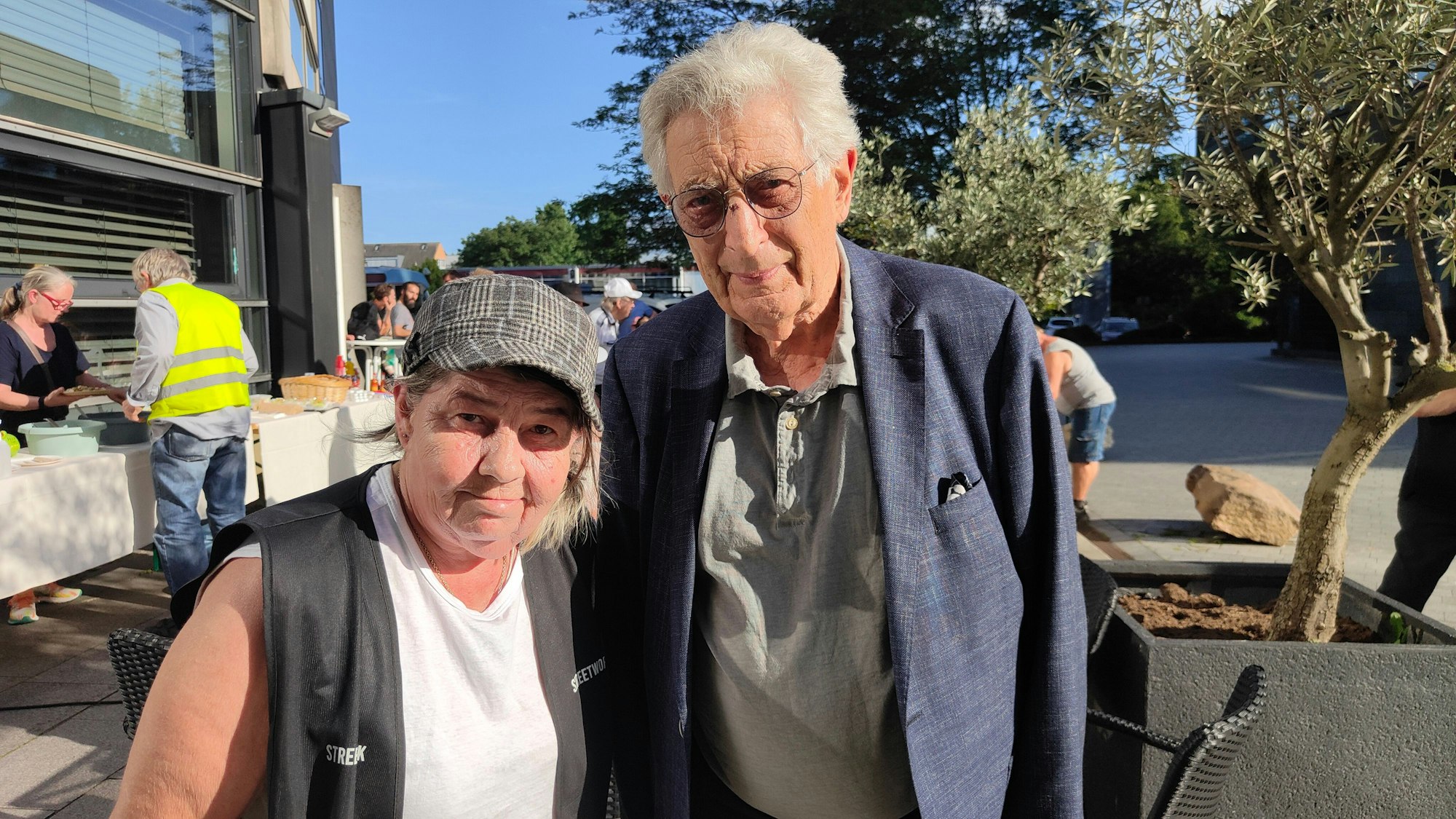 Linda Rennings und Ex-Innenminister Gerhart Baum stehen auf einem Platz in Köln-Mülheim.