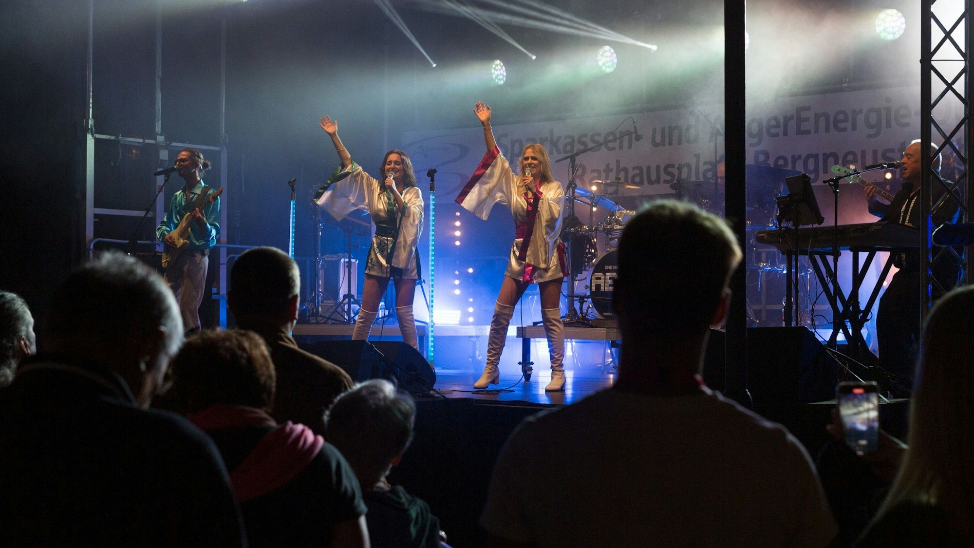 Zwei Sängerinnen stehen auf der Bühne, im Vordergrund das Publikum.