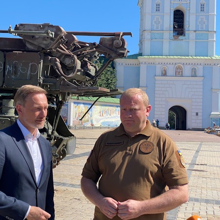 Christian Lindner (FDP, l), Bundesfinanzminister, steht in Kiew neben dem stellvertretenden Verteidigungsminister der Ukraine Andrij Schewtschenko auf dem Michaelsplatz vor erbeuteten russischen Panzern.