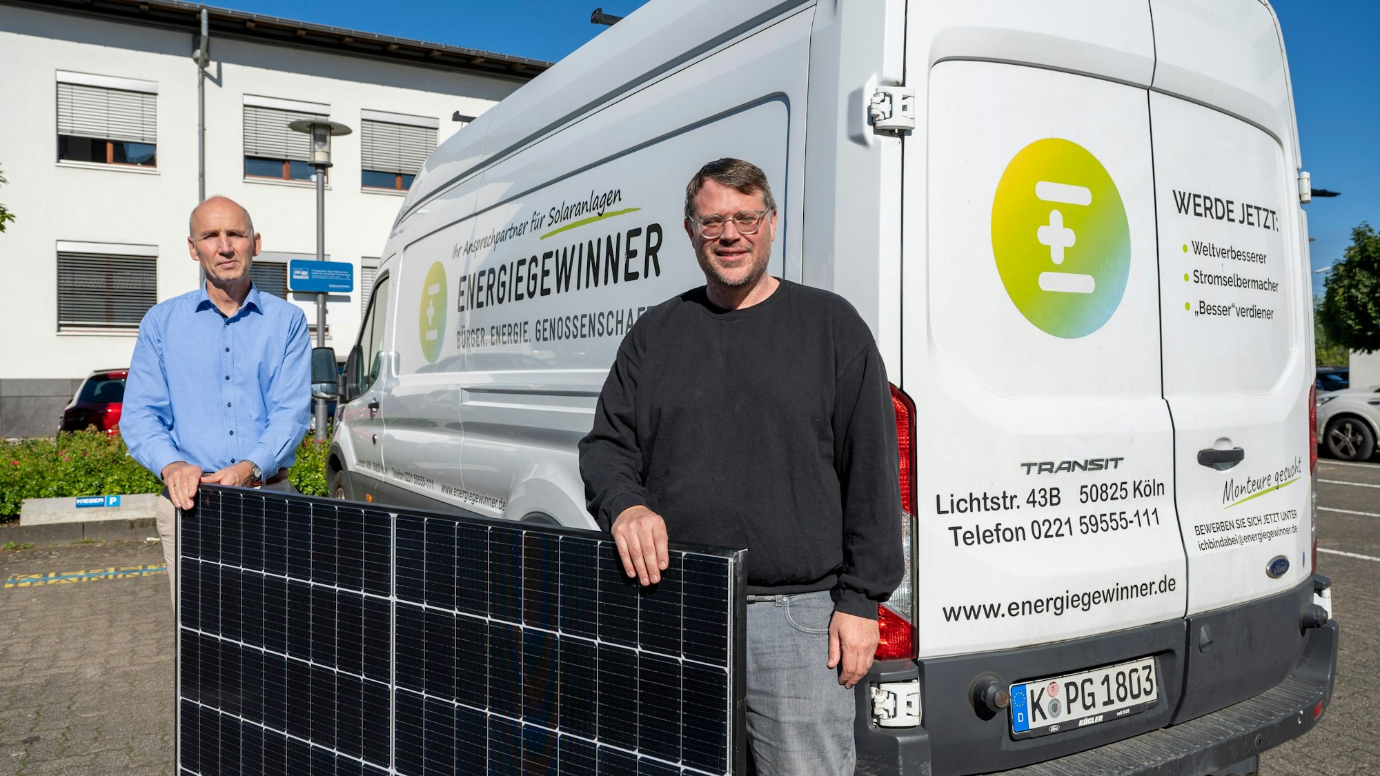 Vorstand Hubert Vienken (l.) und Gründer Kay Voßhenrich mit einem PV-Modul vor einem Kleintransport der Genossenschaft.