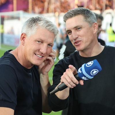 Osnabrücks Trainer Tobias Schweinsteiger (r) steht vor Spielbeginn neben seinem Bruder Bastian Schweinsteiger, der für den übertragenden Fernsehsender ARD als TV-Experte arbeitet.