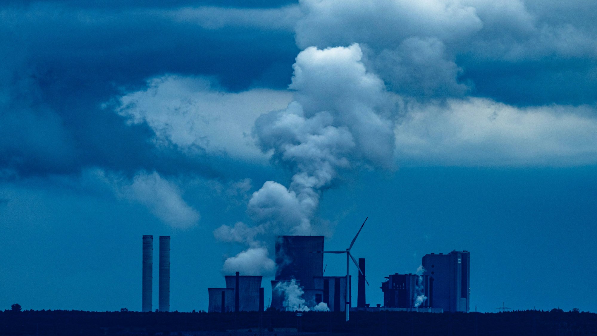 Tagebau Inden, gesehen vom Aussichtspunkt Düren-Merken: Vor graublauem Himmel sind die Bauten des Kraftwerks zu sehen.