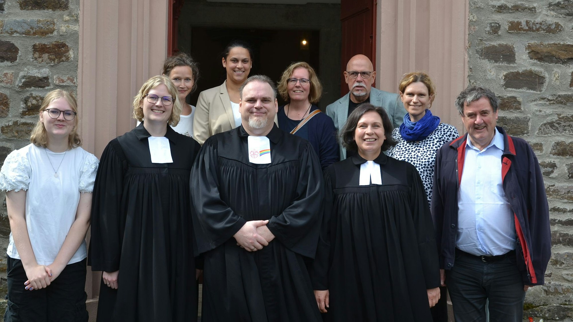 Eine Gruppe Menschen steht vor der Tür zur evangelischen Kirche in Flamersheim. Vorne in der Mitte ist der neue Prädikant Marcel Ogrysek.