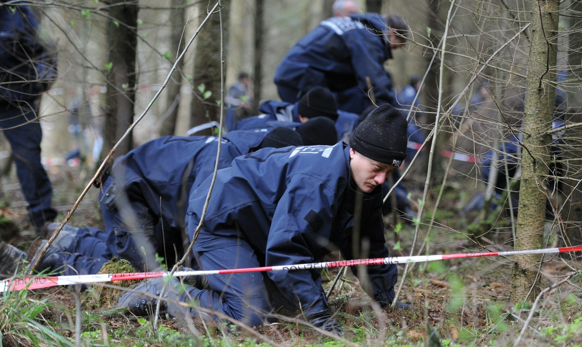 Ein Absperrband der Polizei begrenzt ein Waldgebiet bei Nietheim, das von der Polizei durchsucht wird.