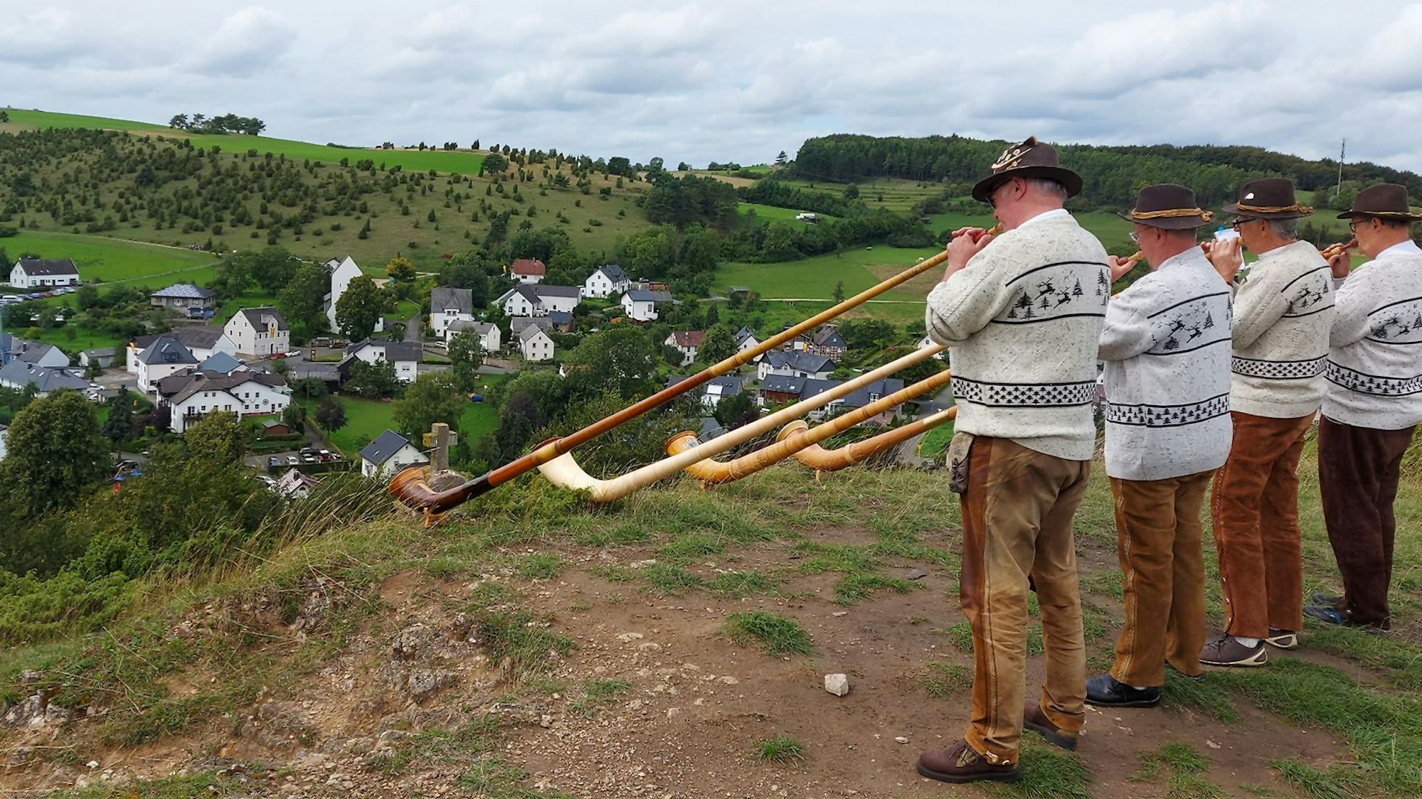 Eine Gruppe Alphornspieler steht auf einer Anhöhe, damit die Klänge ins Tal nach Alendorf getragen werden.