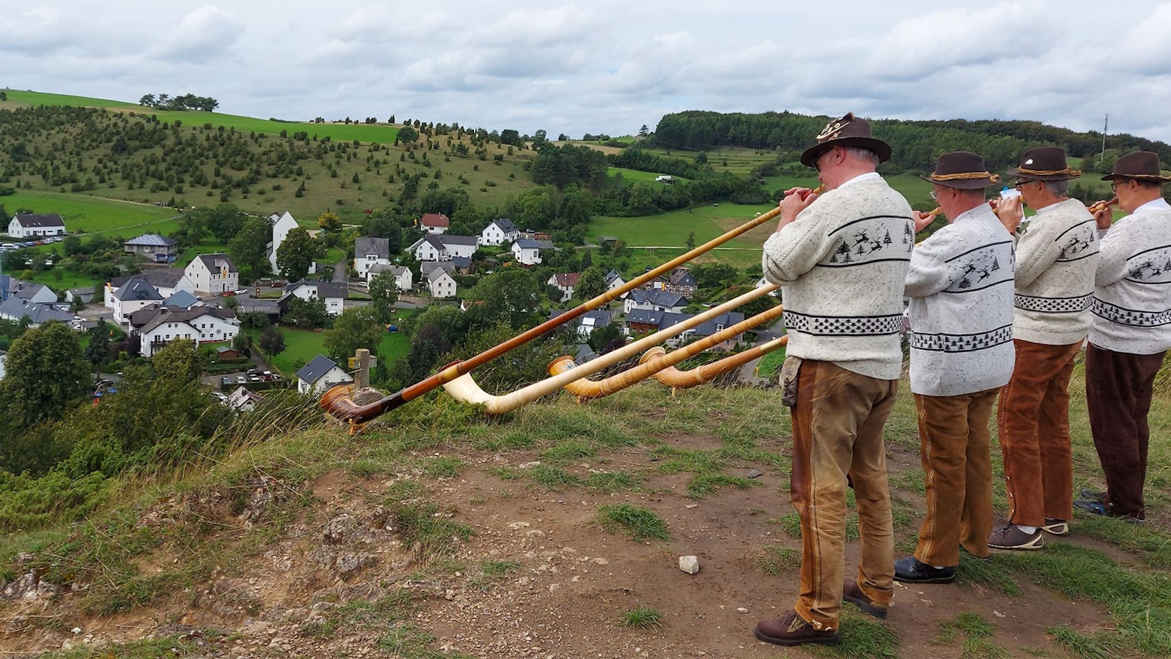 Eine Gruppe Alphornspieler steht auf einer Anhöhe, damit die Klänge ins Tal nach Alendorf getragen werden.