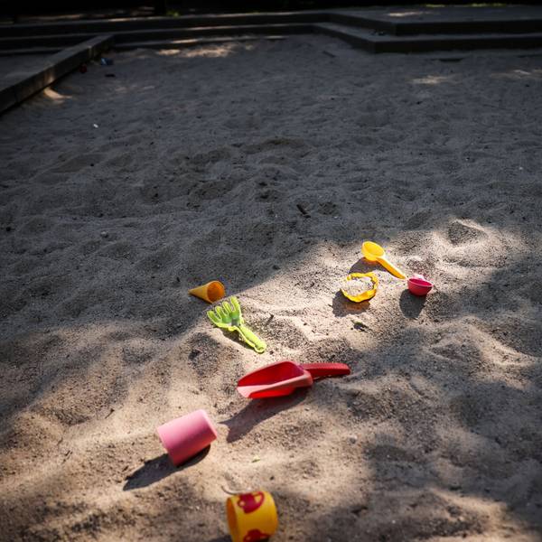 Spielzeug liegt in einer Sandkiste auf einem Spielplatz als Symbol dafür, dass in der Stadt 500 Kita-Plätze fehlen.