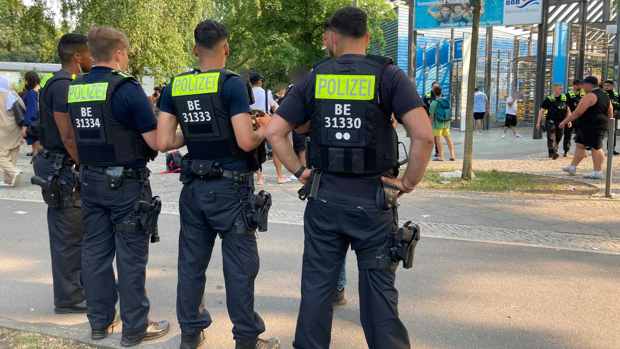 Juli 2023: Berliner Polizisten stehen vor dem Eingang des Sommerbads in Neukölln.