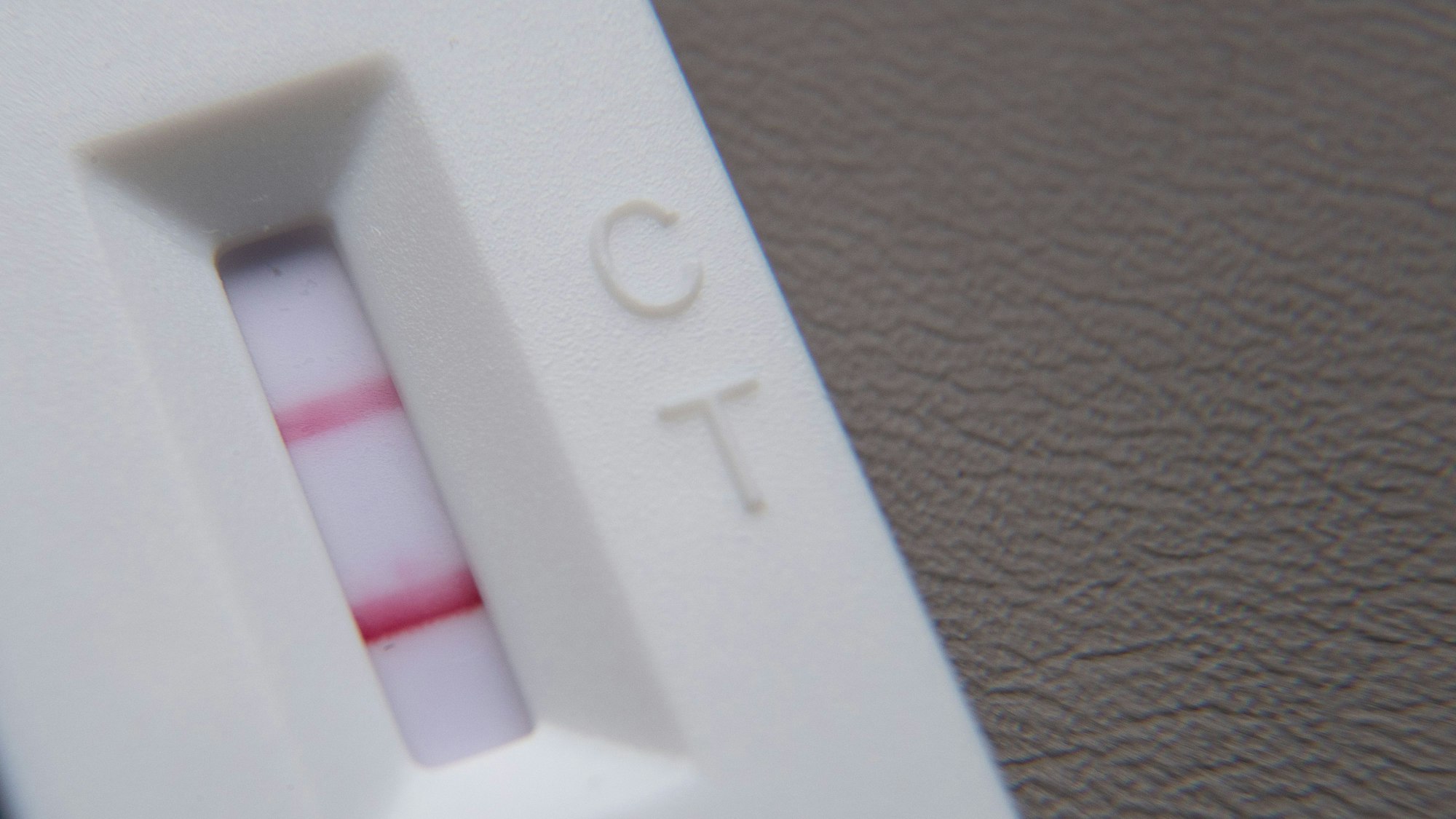 Ein positiver Corona-Schnelltest liegt auf einem Tisch.