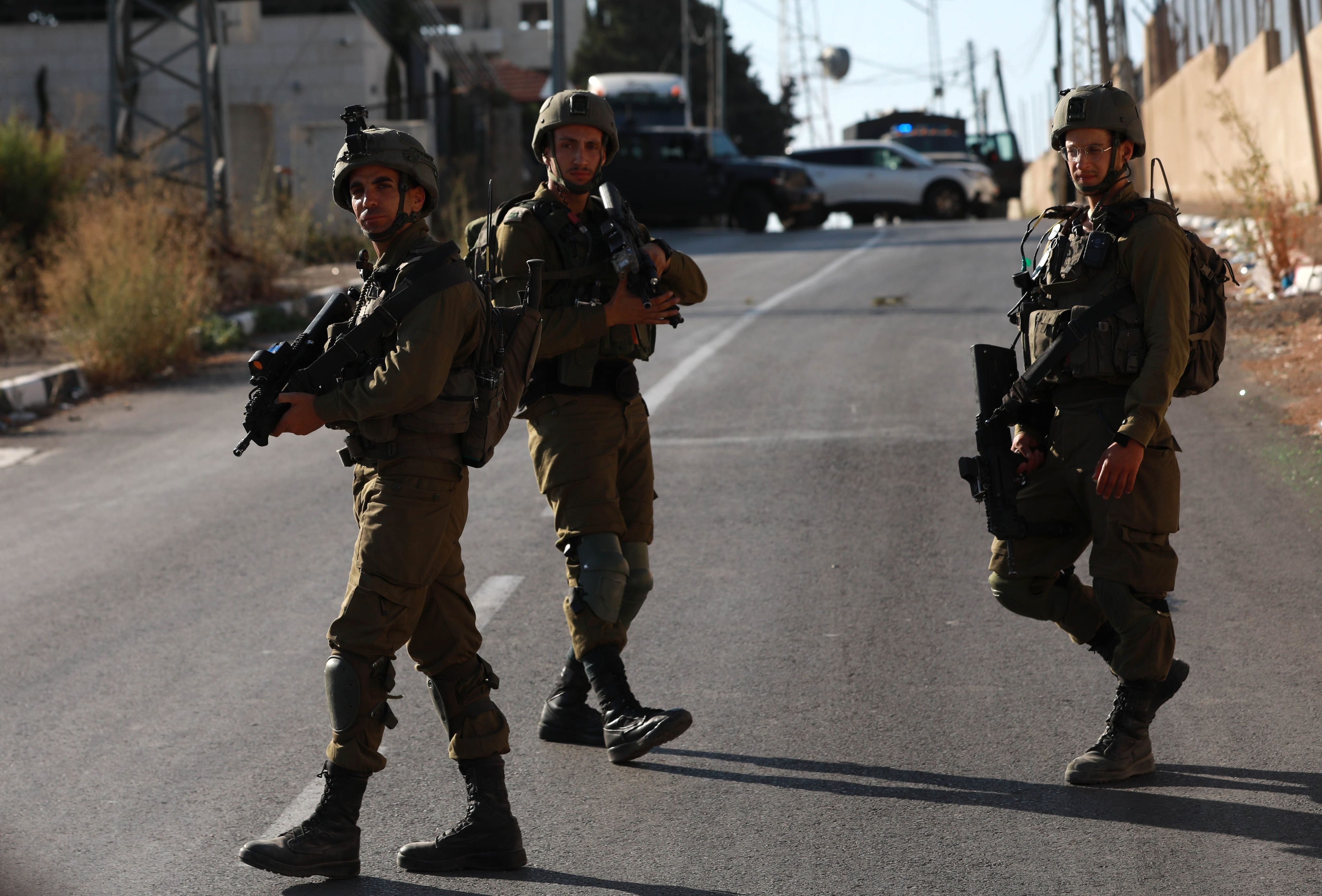 25.07.2023, Palästinensische Gebiete, Nablus: Israelische Soldaten blockieren die Straße, an der mehrere Palästinenser bei einem Zusammenstoß mit israelischen Streitkräften starben.