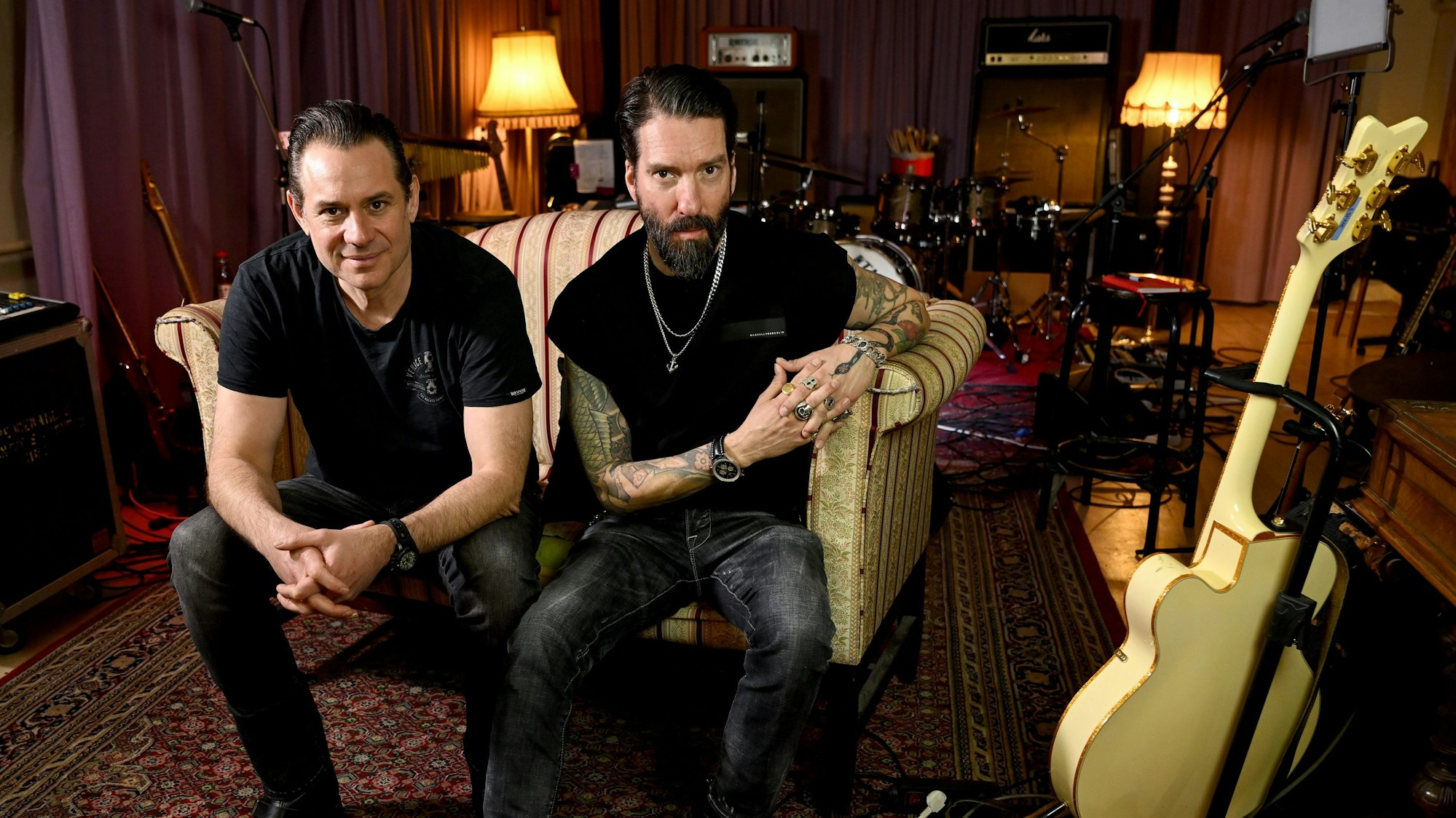 Die Musiker Alec Völkel und Sascha Vollmer sitzen auf einem Sofa.