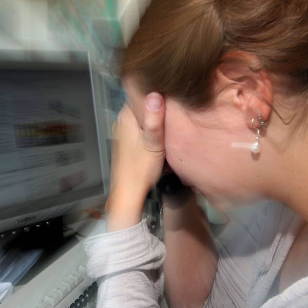 Eine depressive Frau an ihrem Arbeitsplatz (Symbolfoto).