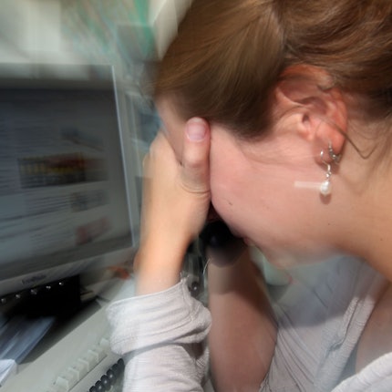 Eine depressive Frau an ihrem Arbeitsplatz (Symbolfoto).